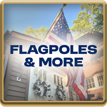 American flag flying on a sturdy flagpole in front of a wooden house with a welcoming entrance.